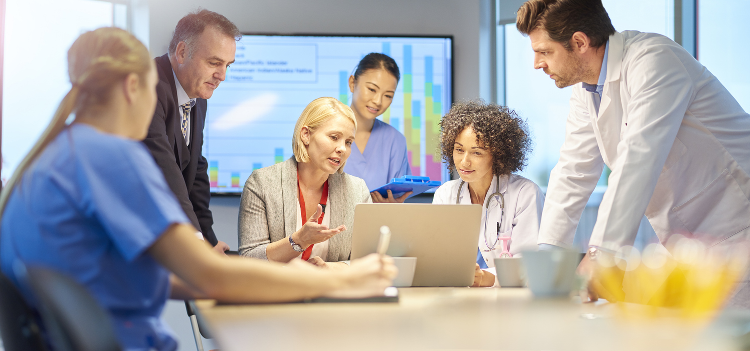 Medical team discussing reports at meeting table