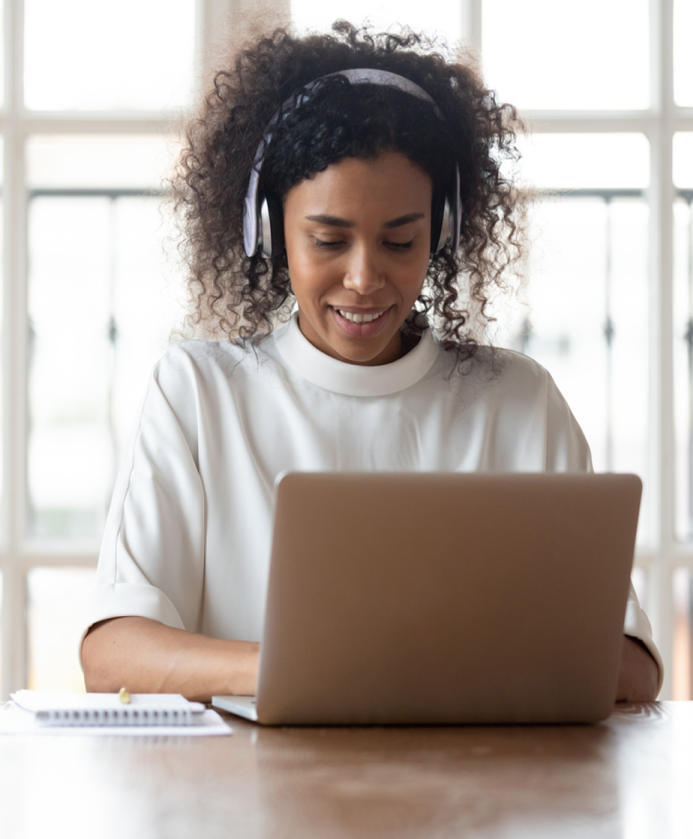 Woman working on laptop with headphones