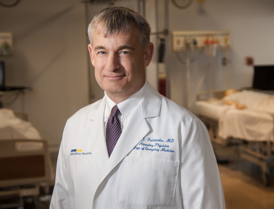 Doctor in a hospital setting, wearing a lab coat.