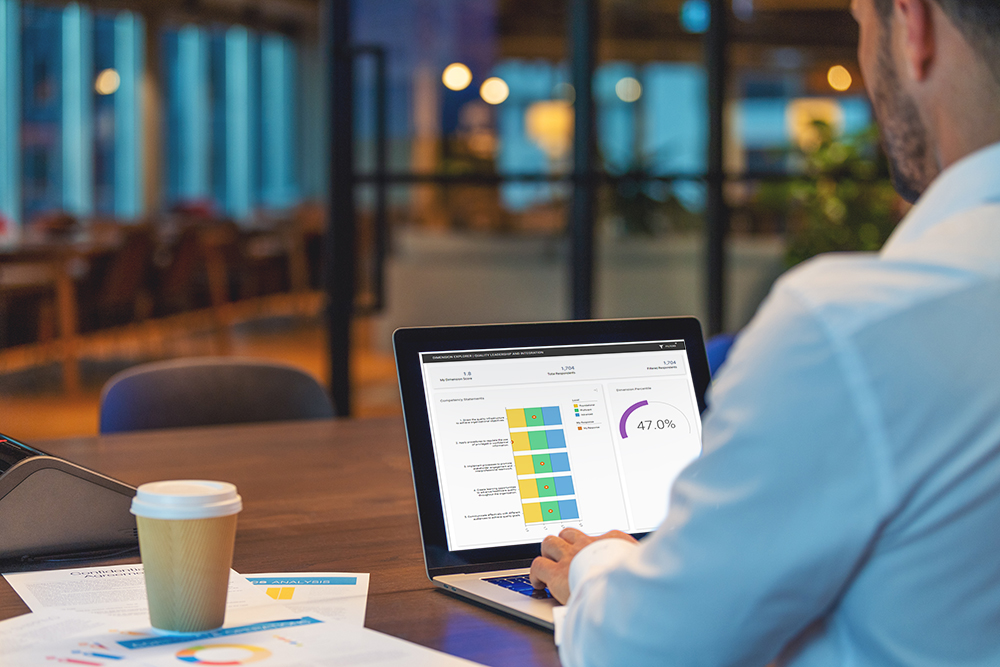 Man analyzing data on laptop in office.