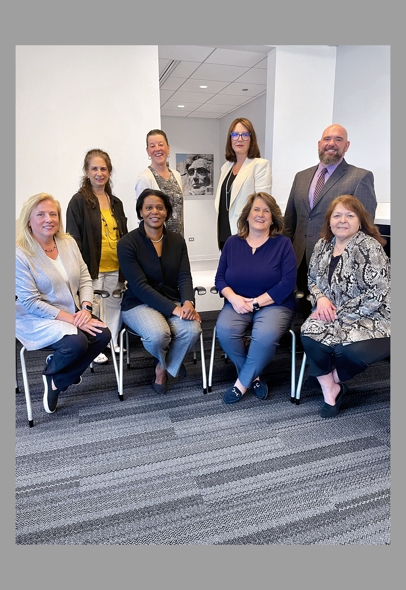 Group of professionals posing in office setting.