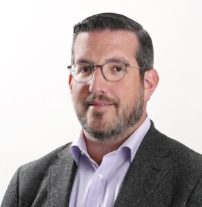 Man with glasses and beard in suit