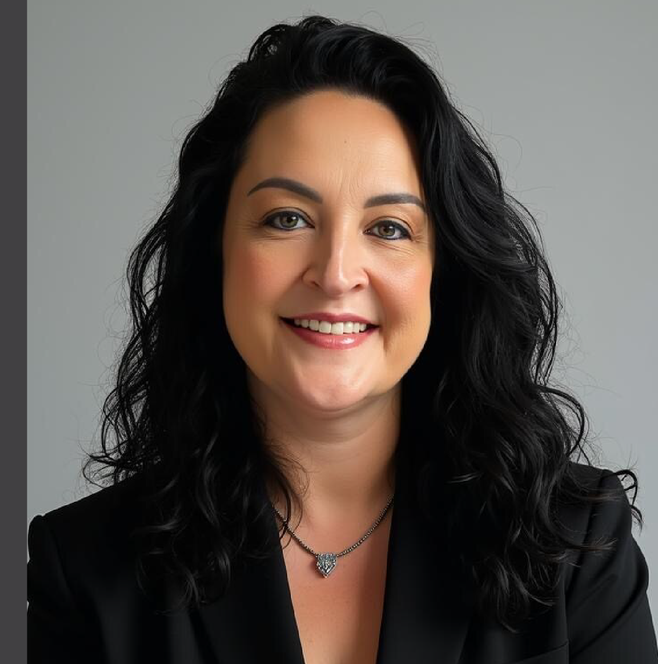 Smiling woman with curly hair and black blazer.