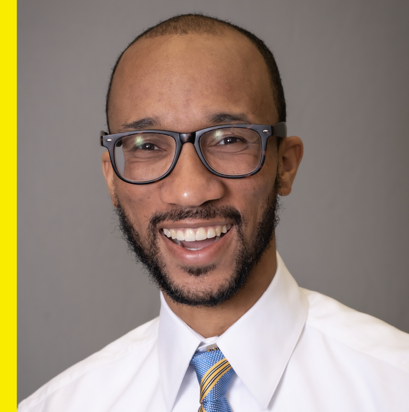 Smiling man wearing glasses and tie
