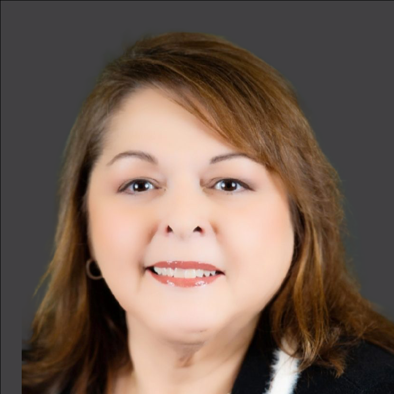 Smiling person with brown hair and gray background.